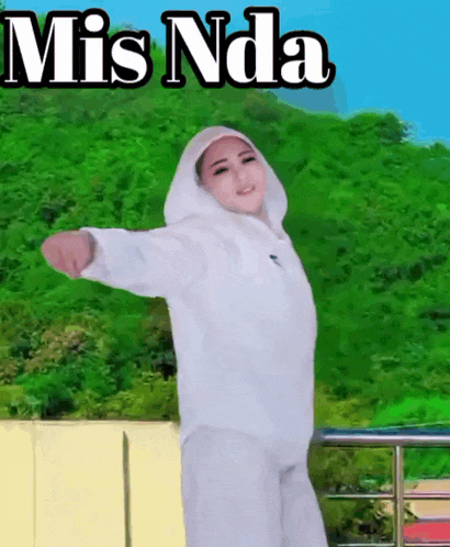 a woman in a white hoodie is standing with her arms outstretched in front of a mis nda banner