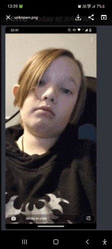 a phone screen shows a picture of a young boy with a batman shirt on