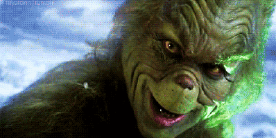 a close up of a grinch 's face with a green background .
