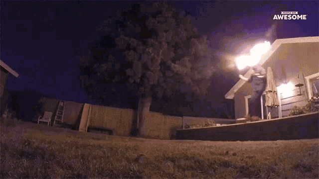 a man throws a fireball in front of a house that says subscribe to awesome on the bottom