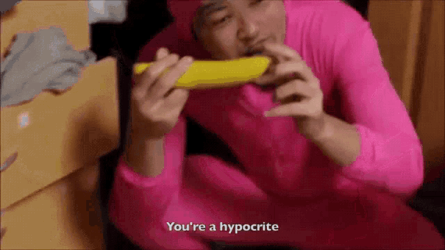a man in a pink bodysuit is eating a banana and saying you 're a hypocrite
