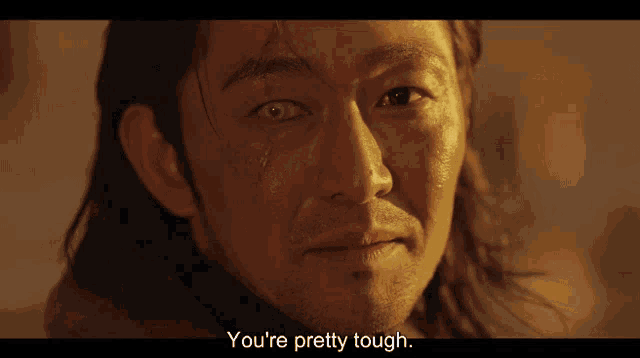 a close up of a man 's face with the words " you 're pretty tough " next to him