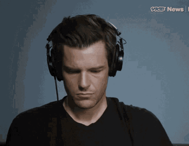 a man wearing headphones with the vice news logo in the background
