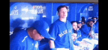 a blue jays player stands in front of a toronto blue jays wall