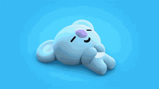 a blue stuffed animal with a purple nose is laying on a blue surface