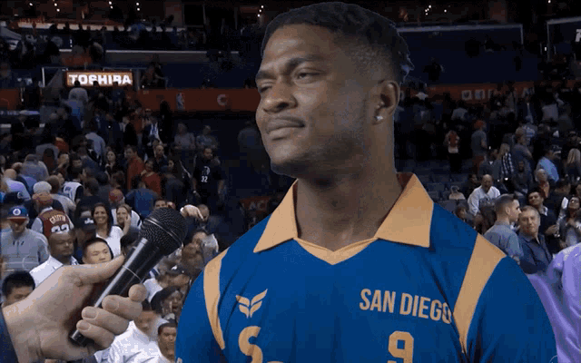 a man wearing a blue san diego jersey talks into a microphone