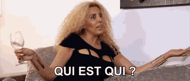 a woman sitting on a couch holding a wine glass with the words qui est qui behind her