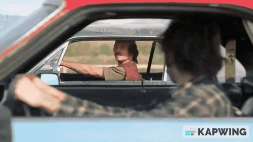 a man driving a car with a kapwing sticker on the door