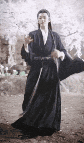 a man in a black kimono is holding a sword in his hand
