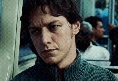 a close up of a man 's face with a gray sweater on