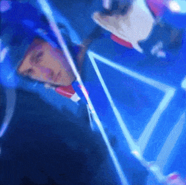 a man 's face is reflected in a triangle in a blue light