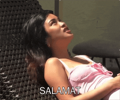 a woman in a pink tank top is laying on a chair with the word salamat written above her