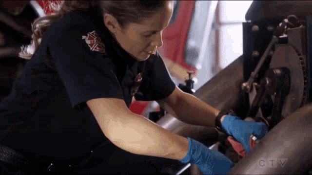a woman in a firefighter uniform is working on a machine with a ctv logo in the background