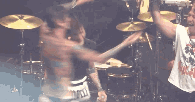 a man in a shirt that says nm is playing drums
