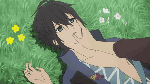 a person laying on the grass with their hand on a man 's face