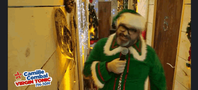 a man dressed as an elf singing into a microphone with camille combal virgin tonic 7h-10h on the bottom
