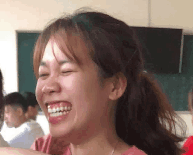 a girl with braces on her teeth is smiling in a classroom