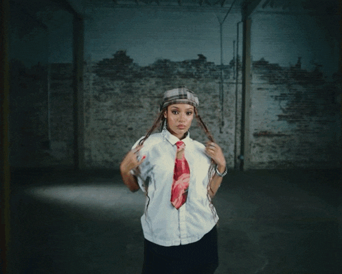 a woman wearing a white shirt and a red tie holds her hands to her head