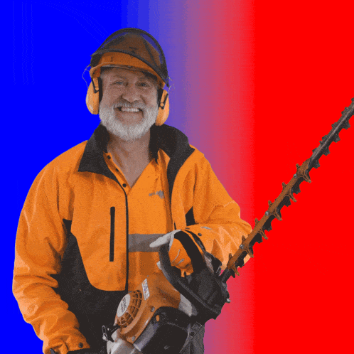 a man in an orange jacket is holding a hedge trimmer and smiling