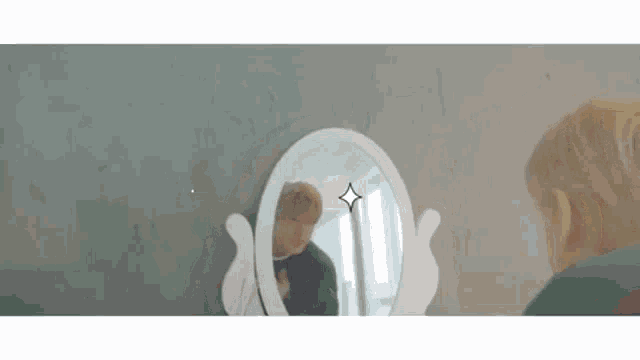 a child is looking at himself in the mirror .