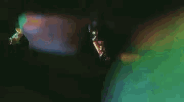 a close up of a woman 's face with a green background and a rainbow in the background .