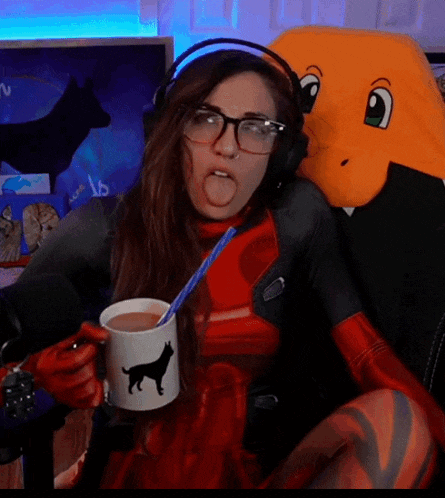 a woman in a deadpool costume is drinking from a mug with a cat on it