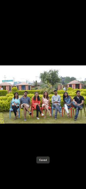 a group of people sitting in chairs in a park with a saved button on the bottom