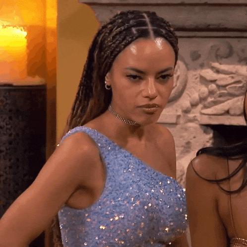 a woman wearing a blue dress and a choker is standing next to another woman