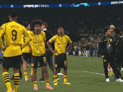 a group of soccer players are standing on a field and one of them has the number 9 on his shirt