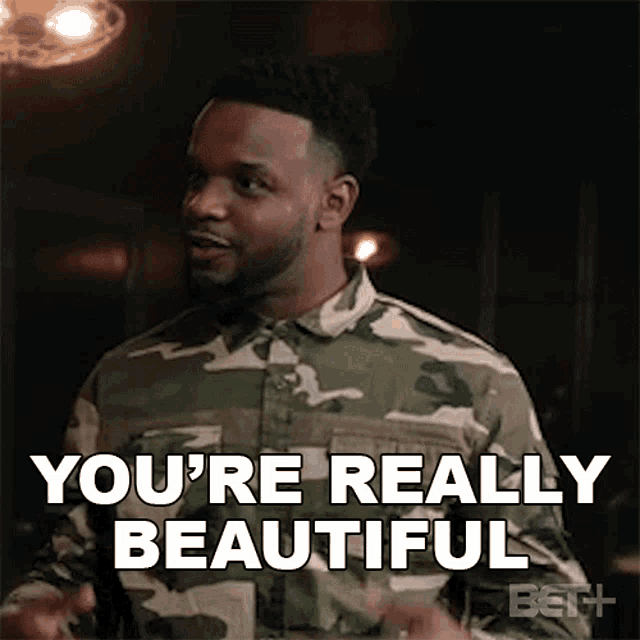 a man in a camouflage shirt is saying you 're really beautiful .