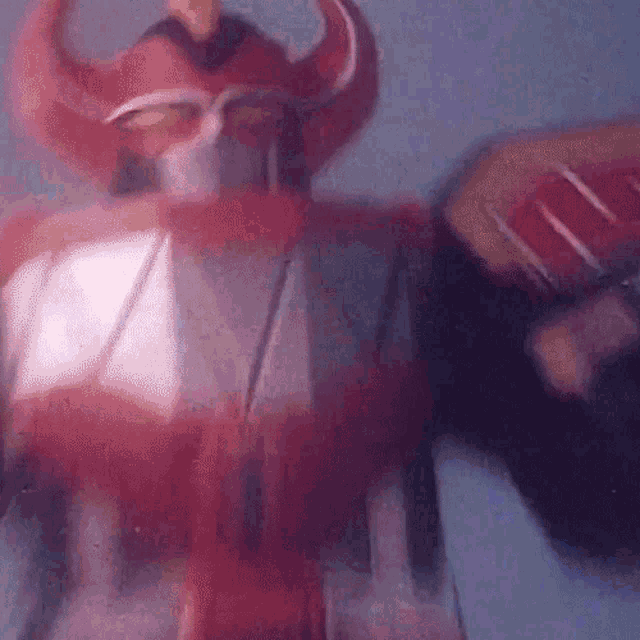 a close up of a red robot with horns on it 's head
