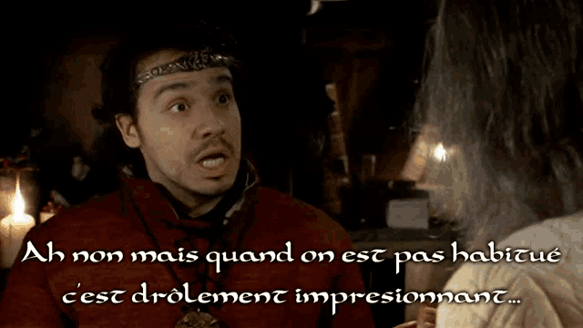 a man with a crown on his head is talking to another man in a foreign language