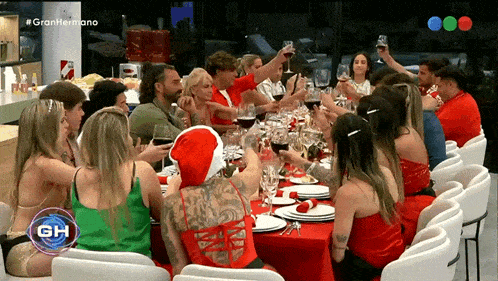 a group of people are sitting at a table with a sign that says granhermano