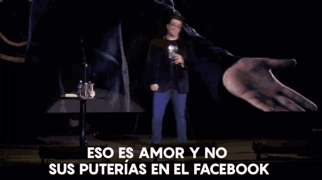 a man holding a microphone on stage with the words eso es amor y no sus puterias en el facebook