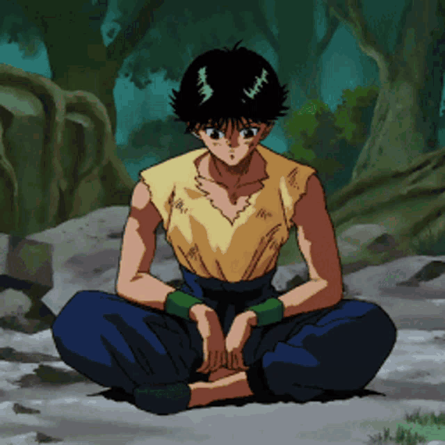 a man in a yellow shirt sits on a rock