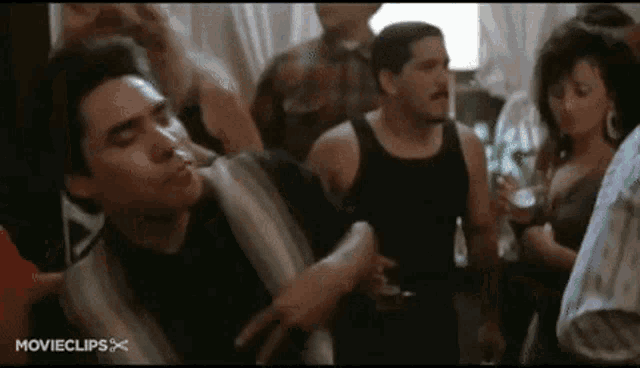 a man is dancing in a crowd of people at a party in a room .
