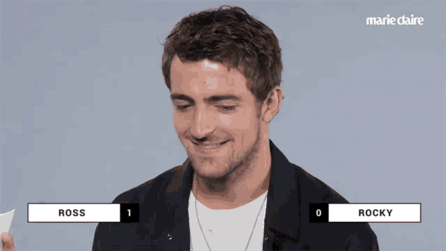 a man in a black jacket is smiling while holding a cup with the name ross on it