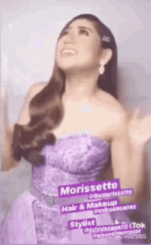 a woman in a purple dress is standing with her hands in the air .