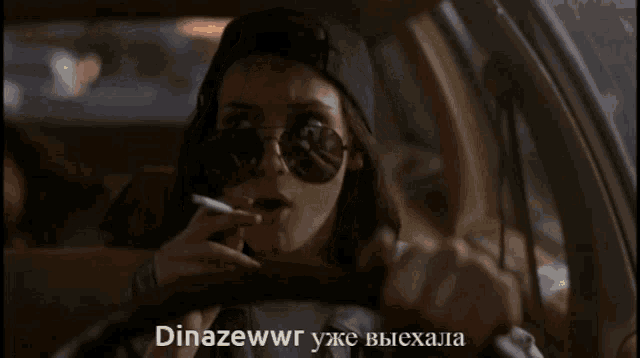 a woman is smoking a cigarette in a car with the words dinazewwr written below her