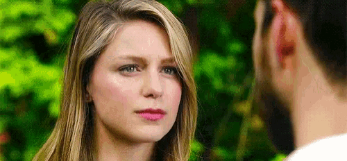 a close up of a woman looking at a man with a beard .