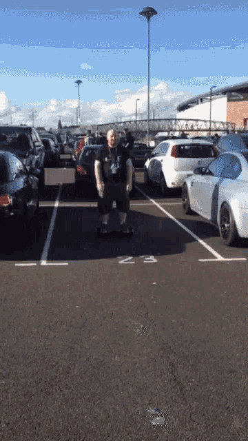 a man is standing in a parking lot with a handicap sign