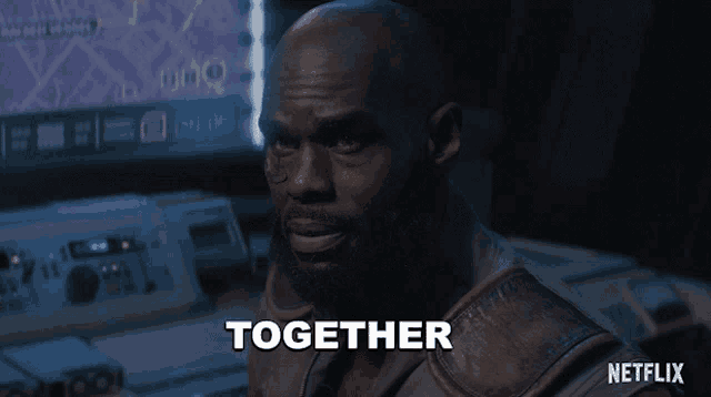 a man with a beard says together in a dark room