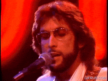 a close up of a man singing into a microphone with gifrun.com in the corner