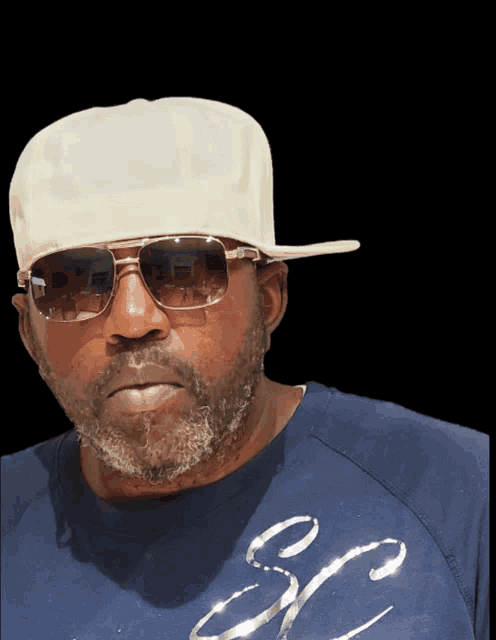 a man wearing a white hat and sunglasses is wearing a blue shirt with the letter s on it