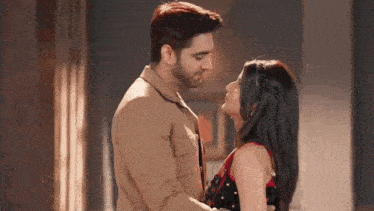 a man and a woman are standing next to each other and kissing .