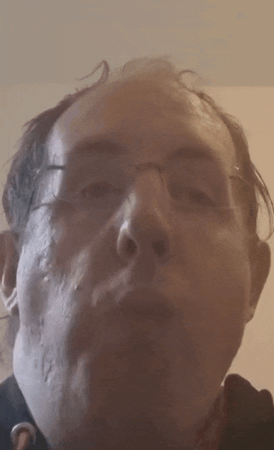a close up of a man 's face wearing glasses