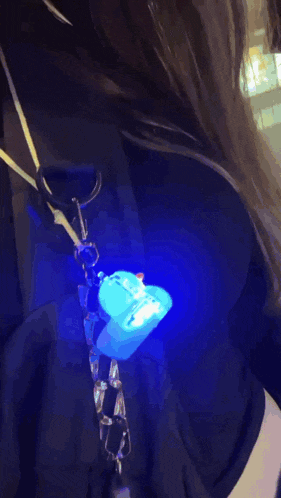 a person is holding a keychain that has a red light on it