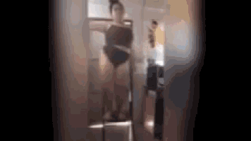 a woman is standing in front of a mirror in a dressing room .