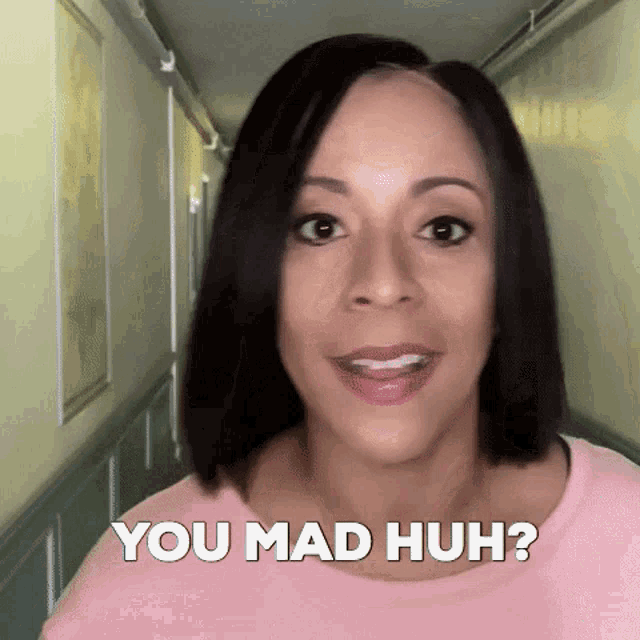 a woman in a hallway with the words you mad huh behind her