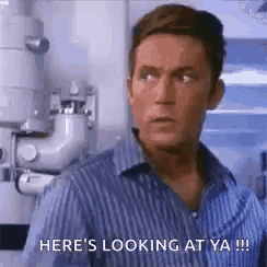 a man in a striped shirt is standing in front of a pipe and says `` here 's looking at ya !! ''